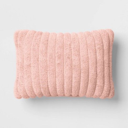 a pink pillow on a white wall