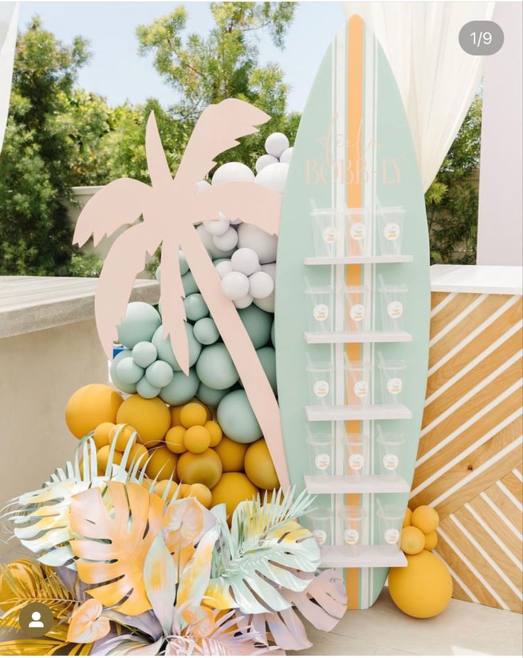 there is a surfboard and some balls on the table with palm trees in the background