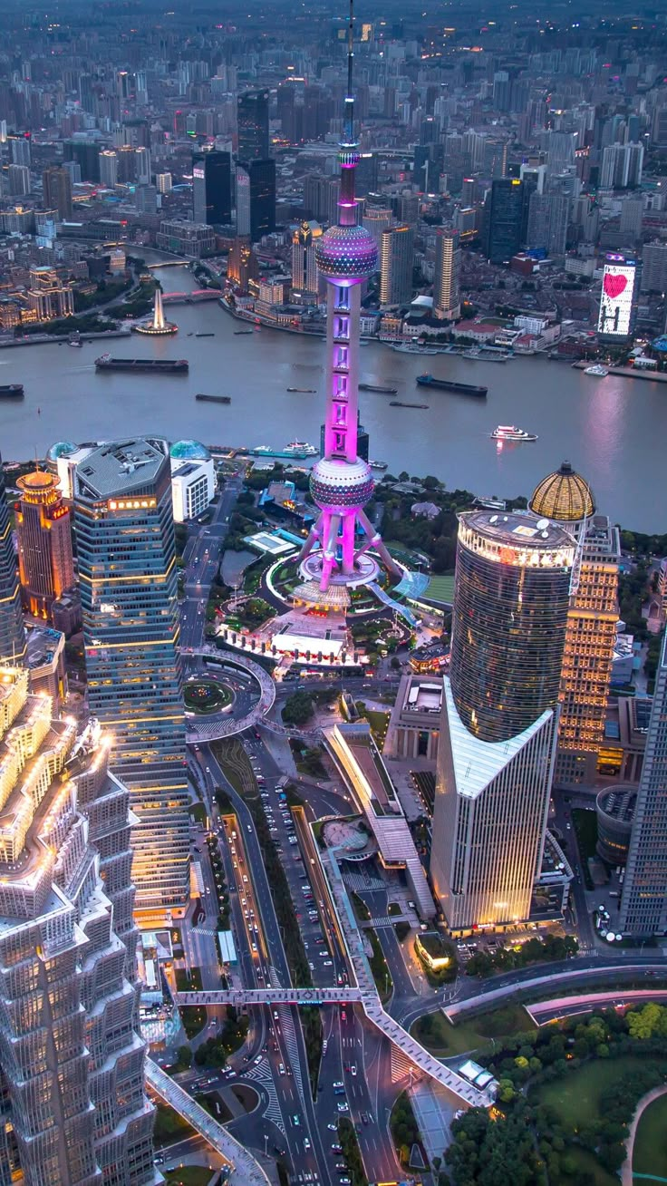 an aerial view of a city at night with the lights on and skyscrapers lit up