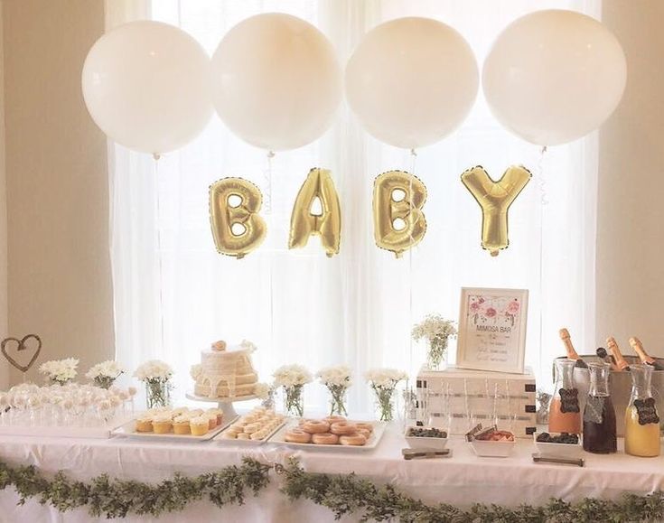 a baby shower table with balloons and cake