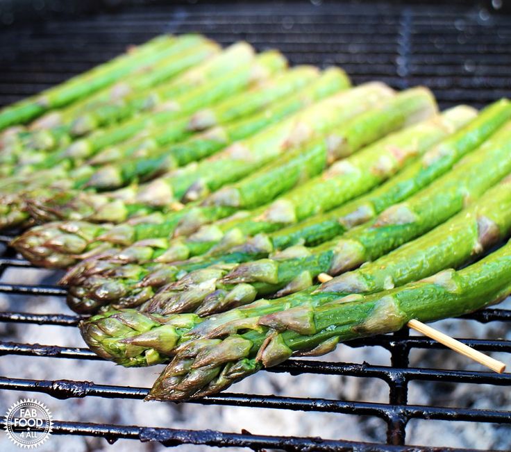 asparagus are being cooked on the grill