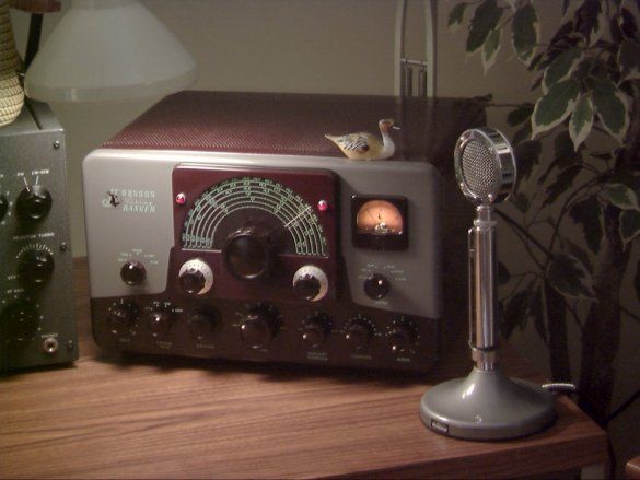 an old radio sitting on top of a wooden table next to a lamp and other electronics