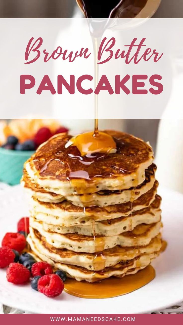 a stack of pancakes with syrup being drizzled over them and berries on the side