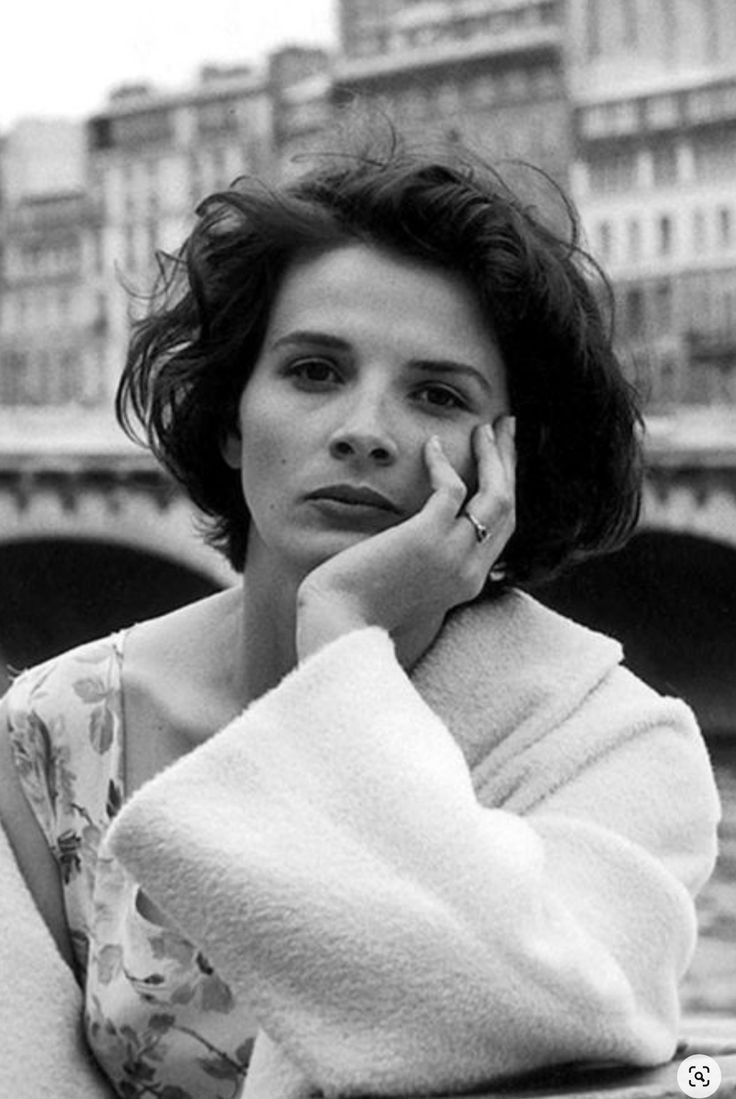 black and white photograph of a woman leaning against a railing with her hand on her face