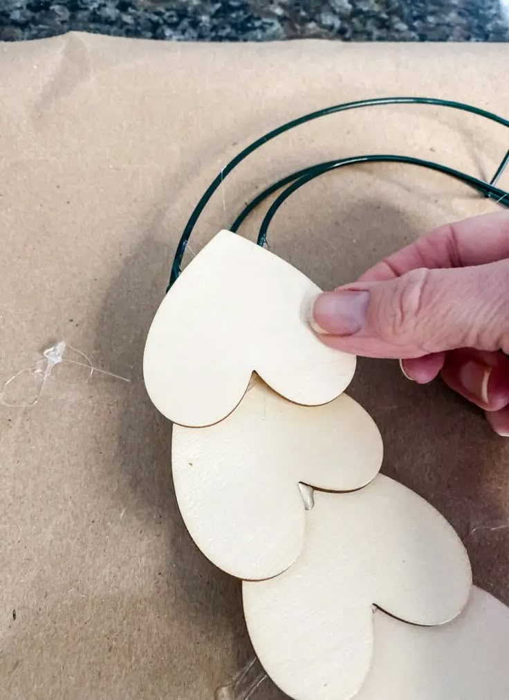 a person is making wooden hearts out of plywood