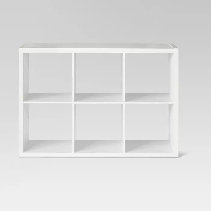 a white shelf with several compartments on each side and one section missing from the wall