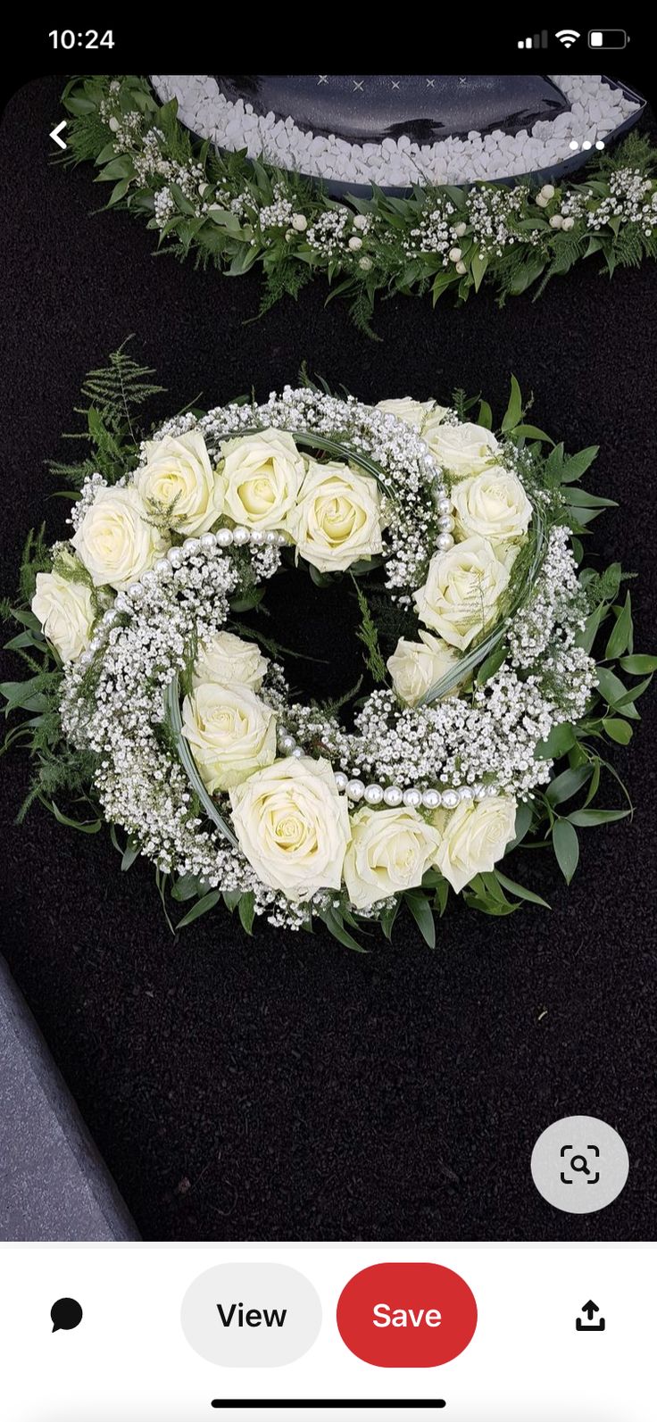 two wreaths with white roses and baby's breath are shown on the phone screen