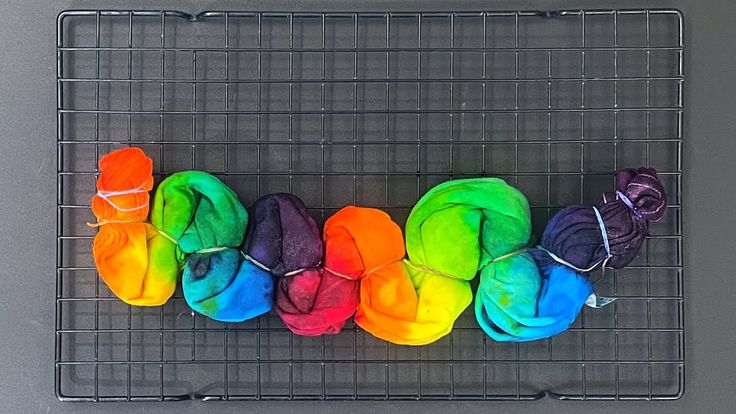 several balls of yarn sitting on top of a wire rack