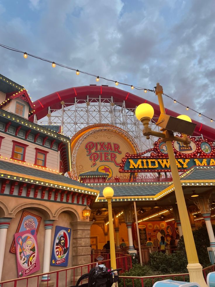 an amusement park at dusk with lights on the top and sign above it that says midway man