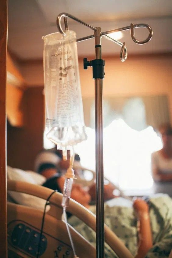 a hospital bed with an oxygen tube attached to it and two people in the background