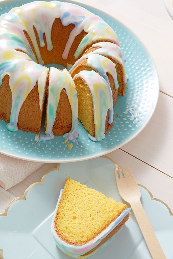 a bundt cake with icing on a plate next to a piece of cake