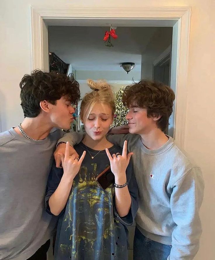 three young people standing in front of a mirror making the peace sign with their hands