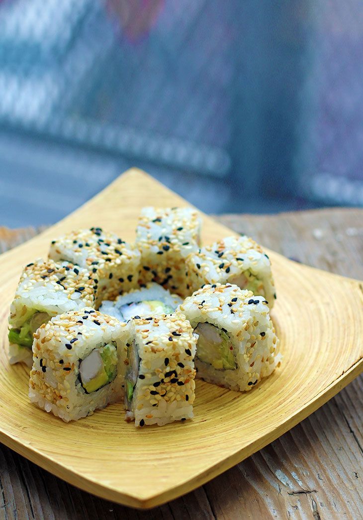 sushi on a yellow plate sitting on a wooden table