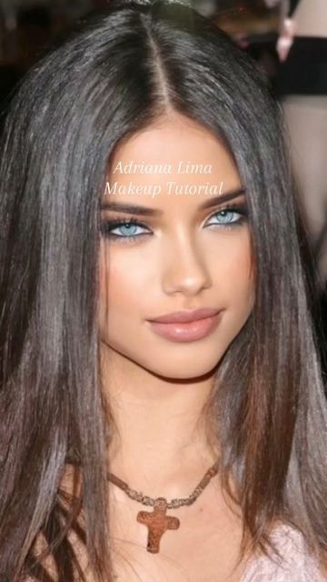 a woman with long hair and blue eyes wearing a cross necklace on her neck is looking at the camera