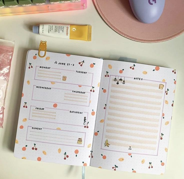 an open planner book sitting on top of a desk next to a mouse and other office supplies