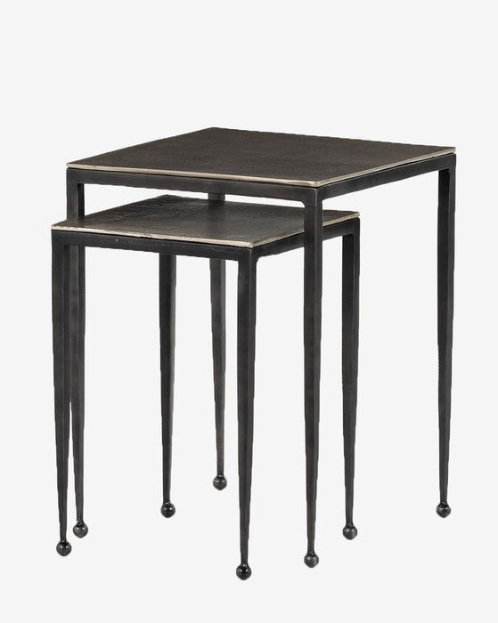 three nesting tables with metal legs and black wood tops, one on each end table