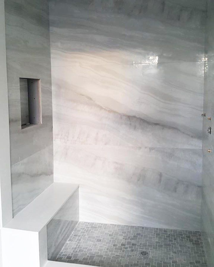 a bathroom with white marble walls and floor