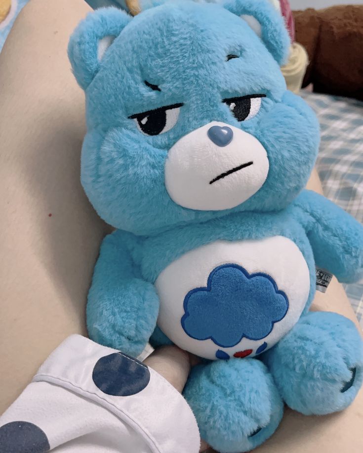 a blue teddy bear sitting on top of a couch