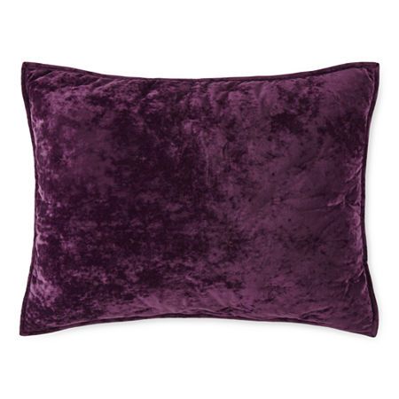 a purple velvet pillow on a white background