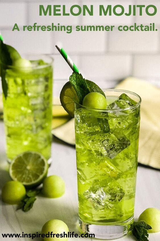 two glasses filled with lemonade and limes on top of a table next to green fruit