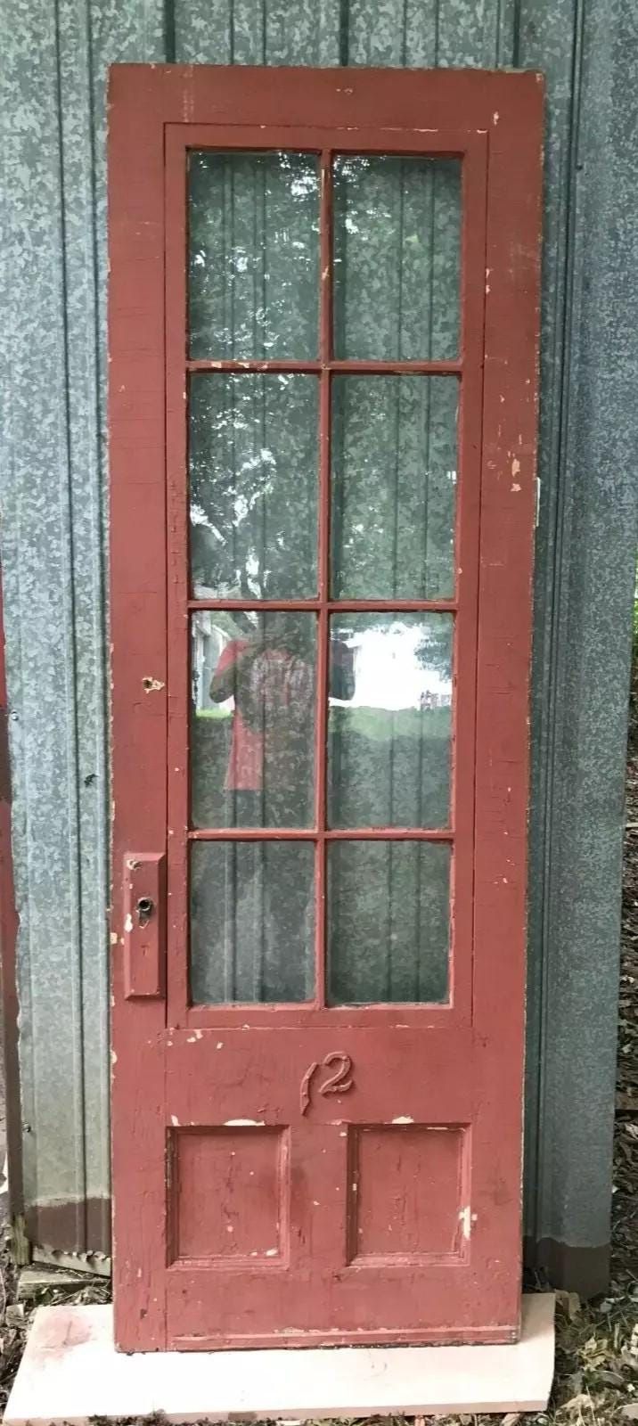 an old red door with glass on it