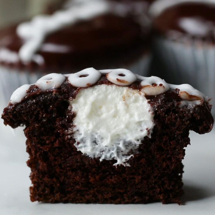 a chocolate cupcake with white frosting and sprinkles on the top