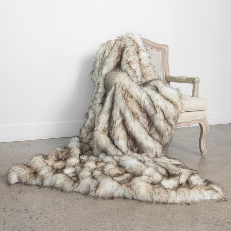 a pile of yarn sitting on top of a floor next to a white chair and wall