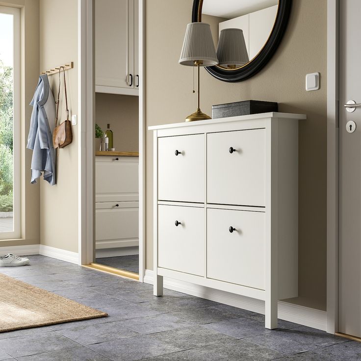 a white dresser sitting in front of a mirror