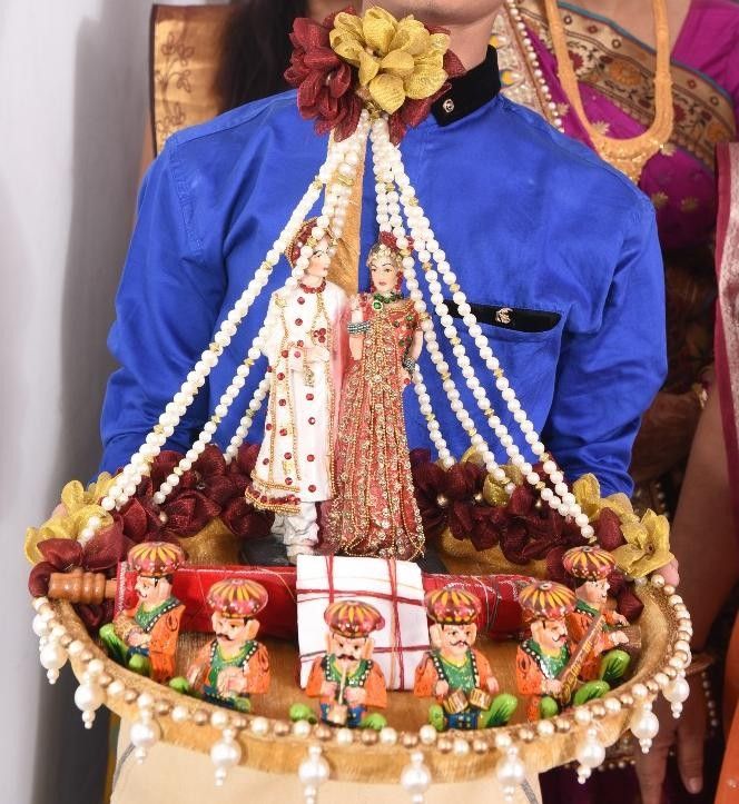 a man in blue shirt holding a tray with decorations on it