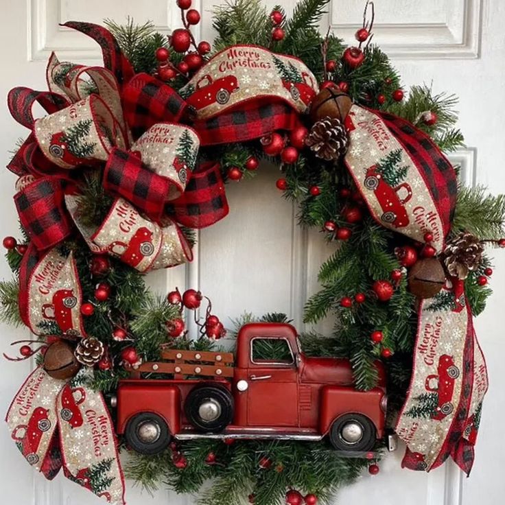 a christmas wreath with a red truck and pine cones