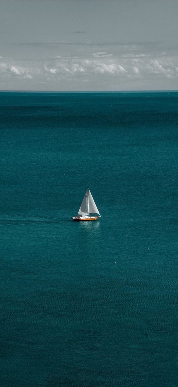 a small sailboat floating on top of a large body of water