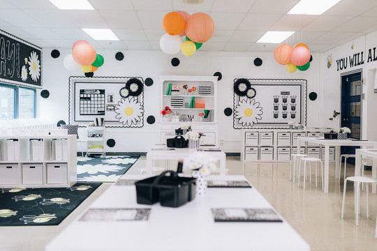 a classroom with tables, chairs and balloons