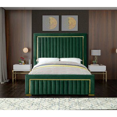 a bed with green velvet upholstered headboard and foot board in a bedroom