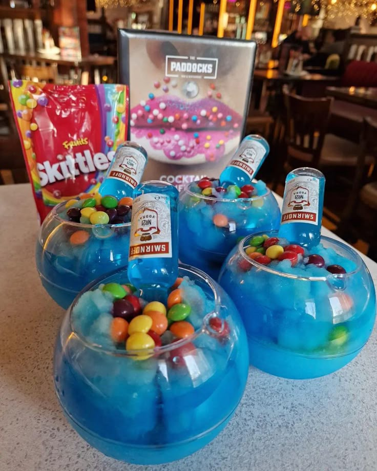 four blue bowls filled with candy and candies on top of a table in a restaurant