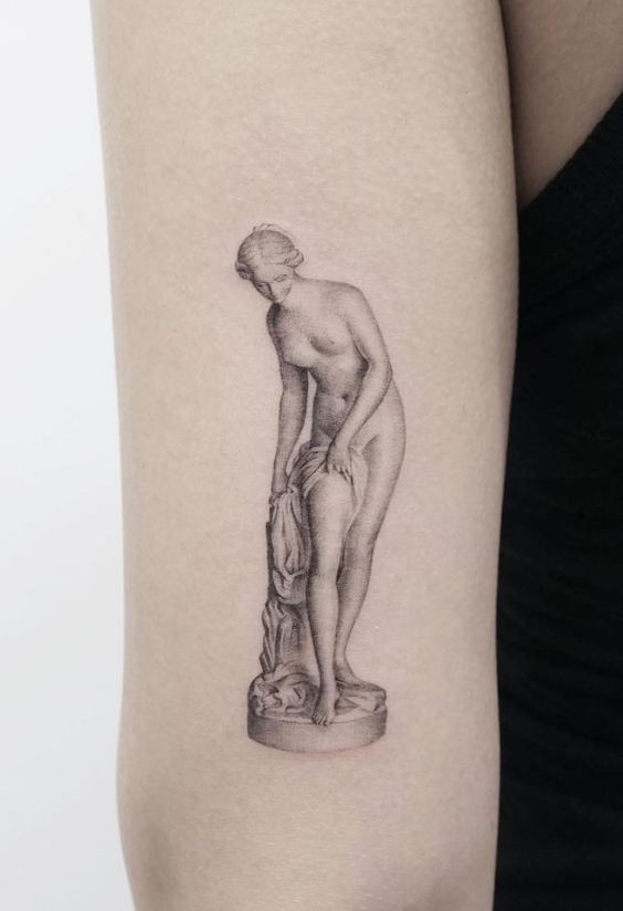 a woman with a statue tattoo on her arm