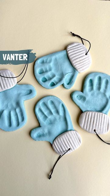 four blue and white handprinted cookies are on a table next to a string