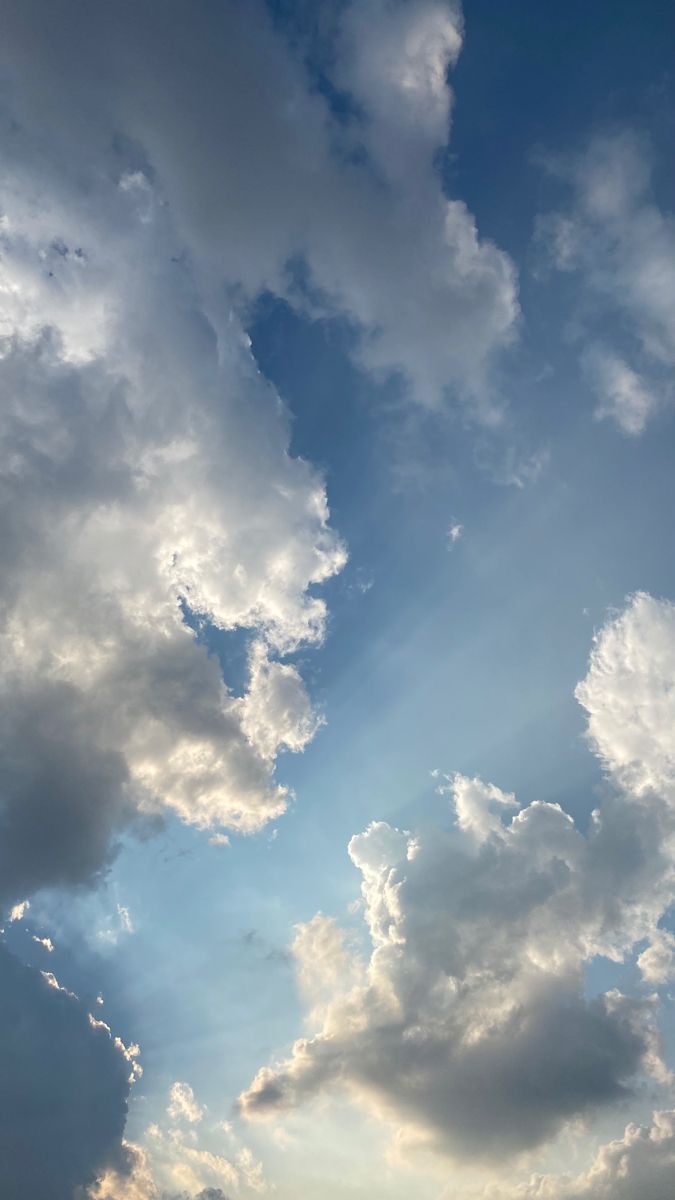 an airplane is flying through the sky with clouds in the backgrounnds