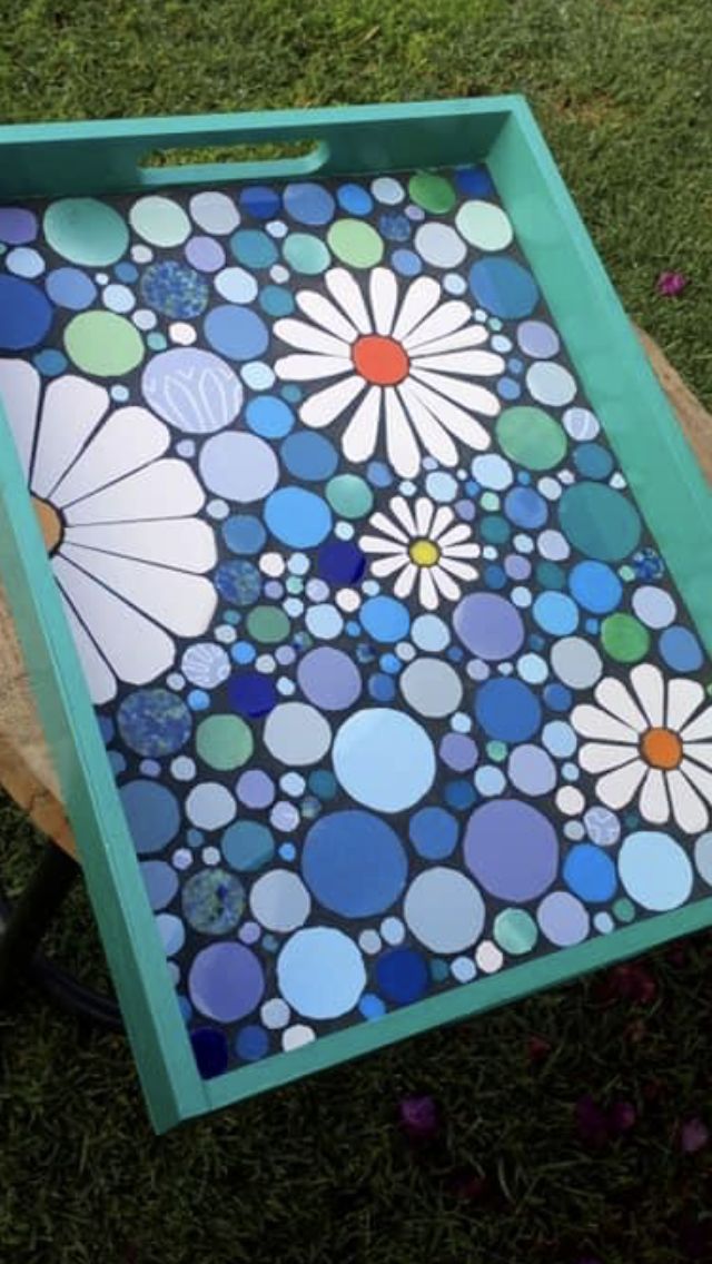 a blue tray sitting on top of a wooden table covered in lots of dots and flowers