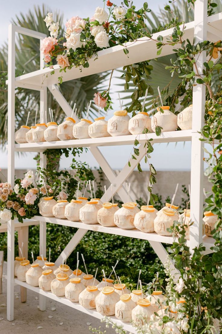 an outdoor wedding with cupcakes and greenery on the shelves in front of them