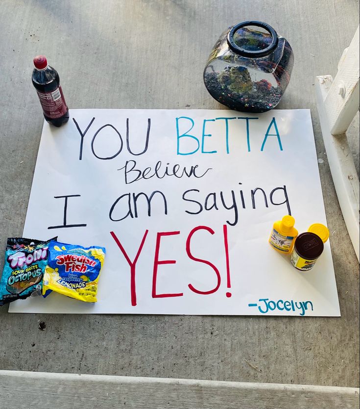 a sign that says you beta believe i am saying yes on the ground next to some snacks