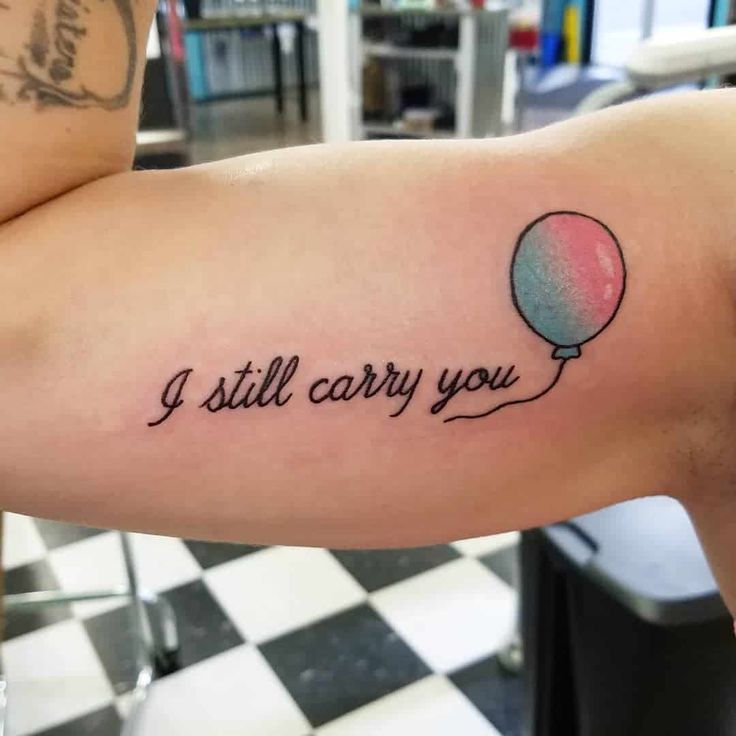 a person with a tattoo that says i still carry you on the side of their arm