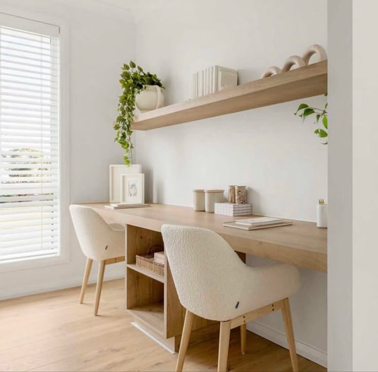 two white chairs sitting at a wooden desk