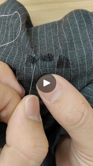 a person is stitching something with their thumbnails to make it look like they are sewing