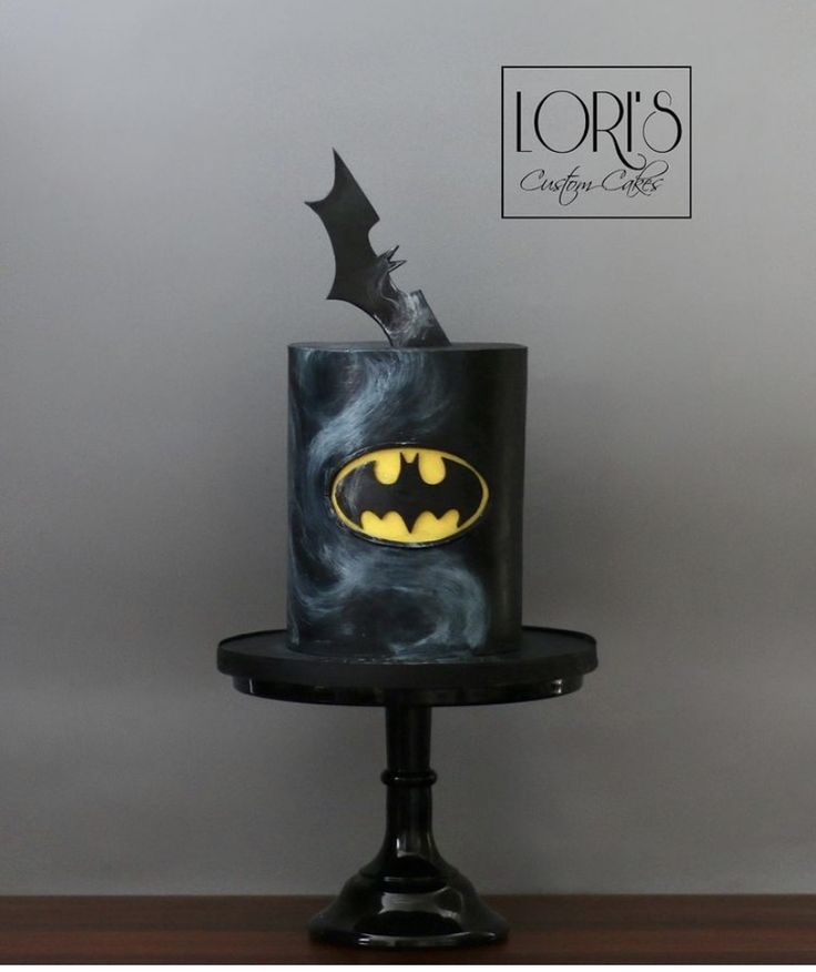 a batman themed cake on top of a black stand with the word lord's written across it