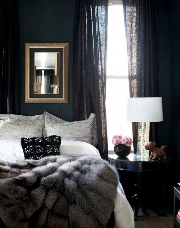 a bedroom with dark green walls and white bedding, two nightstands on either side