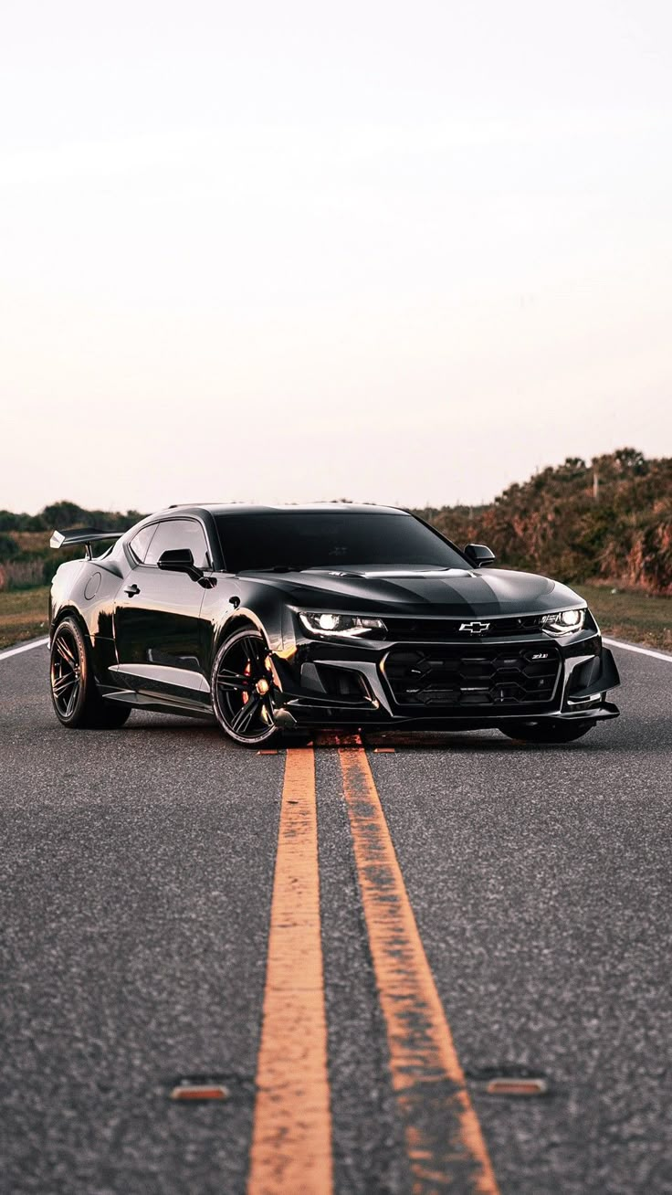 a black chevrolet camaro on the road