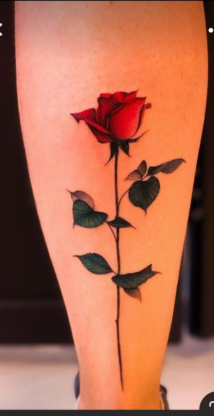 a woman's leg with a rose tattoo on it