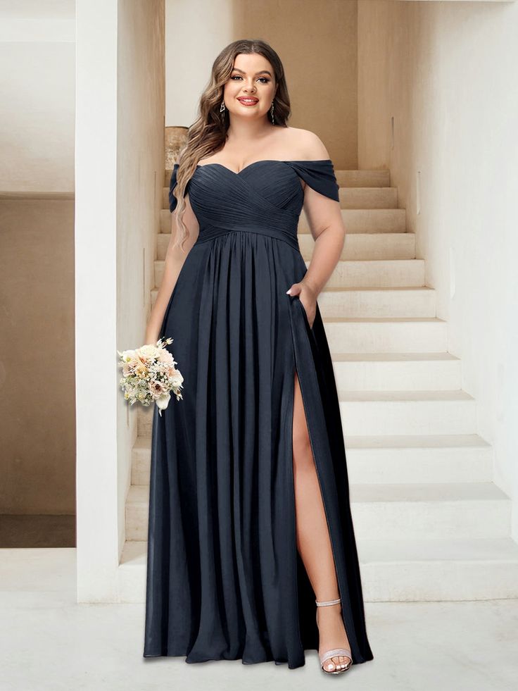 a woman standing in front of stairs wearing a long black dress with thigh high slit