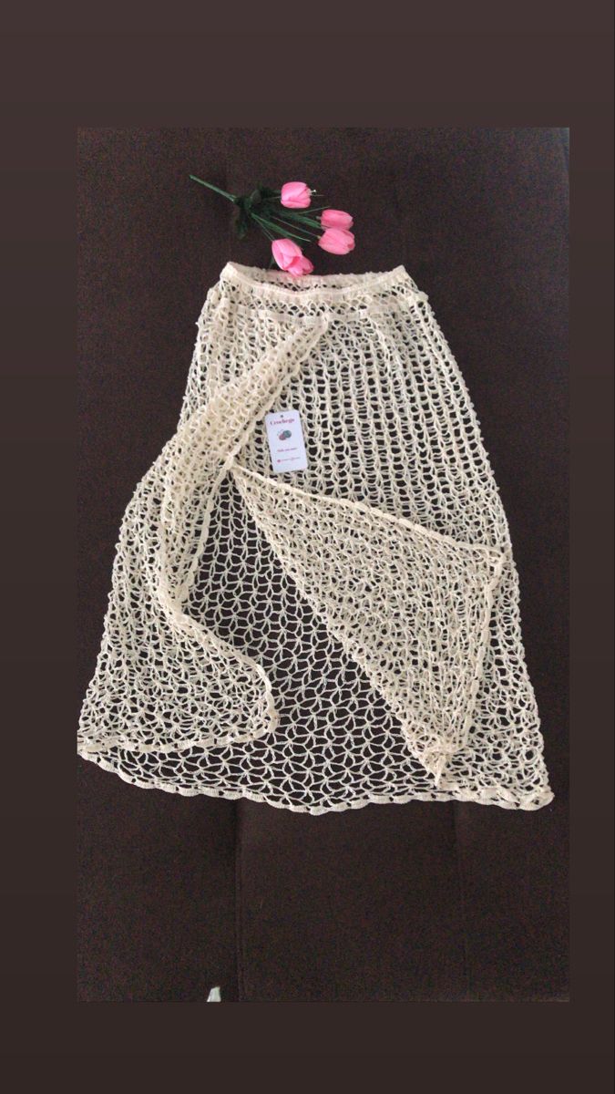 a white netted skirt with flowers on the bottom and one pink flower sticking out of it