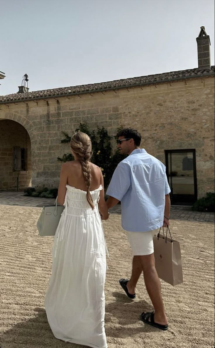 a man and woman walking in front of a building